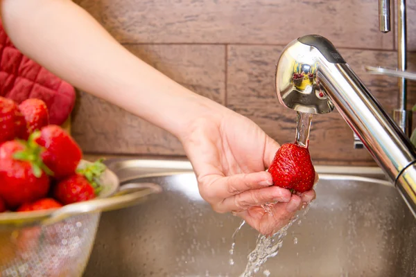 Girl washes strawberries — Stock Photo, Image