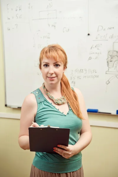 Teacher writes on blackboard — Stock Photo, Image