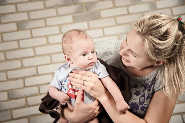 Beautiful woman with a baby in her arms, studio photo — Stok fotoğraf