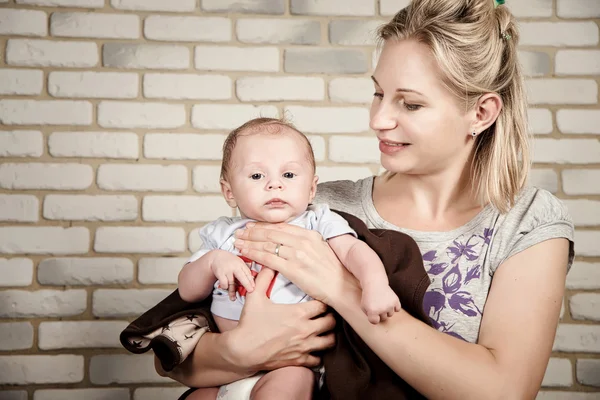 Beautiful woman with a baby in her arms, studio photo — 图库照片