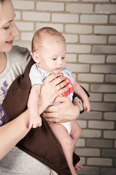 Beautiful woman with a baby in her arms, studio photo — 图库照片