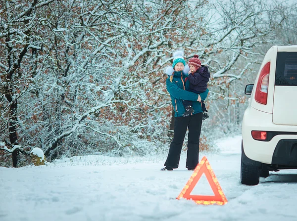 Mulher com uma criança na estrada de inverno . — Fotografia de Stock