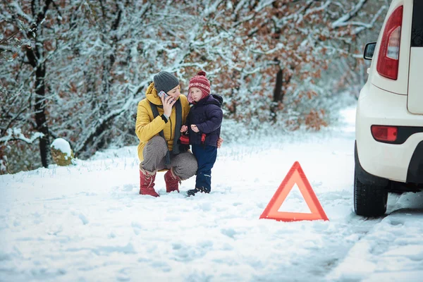 冬の道路の上に子供を持つ女性 — ストック写真