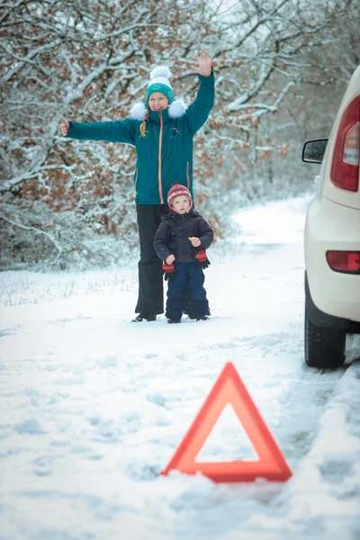 冬の道路の上に子供を持つ女性. — ストック写真