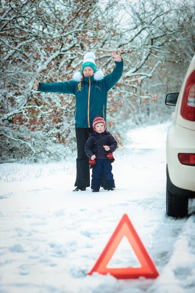 Kvinna med ett barn på vintern vägen. Royaltyfria Stockbilder