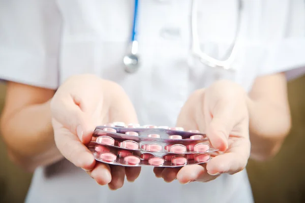 Médico con pastillas en la mano — Foto de Stock