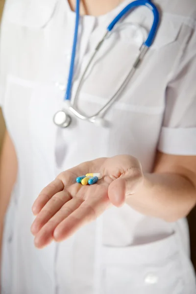 Médico con pastillas en la mano — Foto de Stock