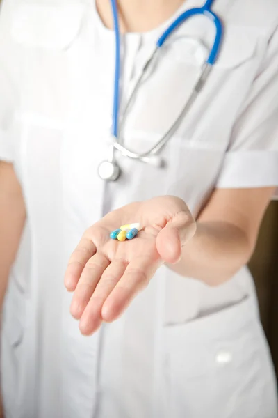 Médico con pastillas en la mano — Foto de Stock