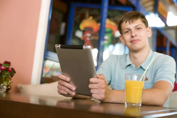 Homem com um laptop em um café — Fotografia de Stock