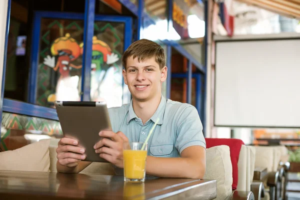 Uomo con un computer portatile in un caffè — Foto Stock