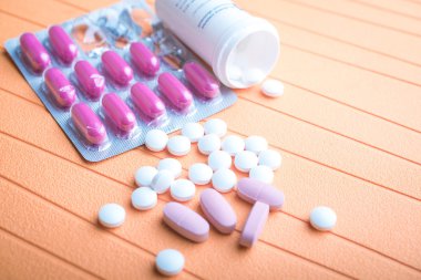 renkli hapları ve arka planda tabletleri