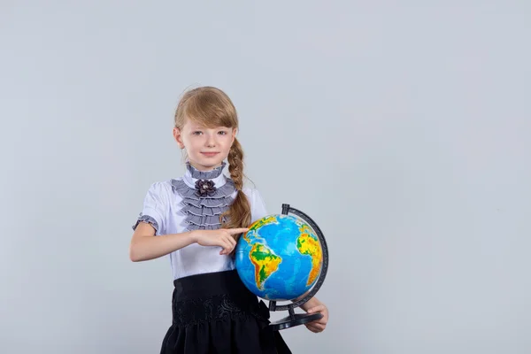 Cute beautiful schoolgirl with a globe — Stock Photo, Image