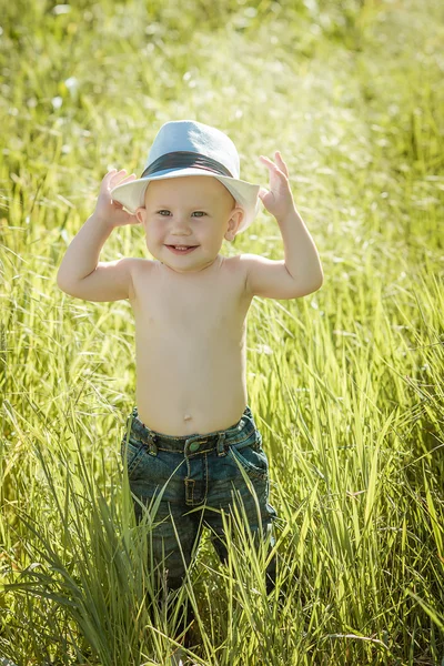 Little boy on the lawn, a child for a walk outdoors — Zdjęcie stockowe