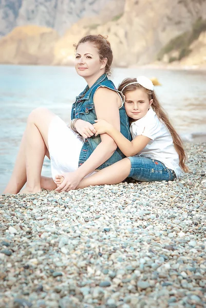 Jeune belle femme avec un enfant sur la plage — Photo