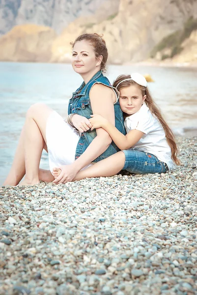 Young beautiful woman with a child on the beach — 图库照片