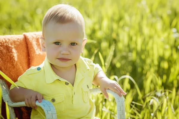 Little boy on the lawn, a child for a walk outdoors — Zdjęcie stockowe