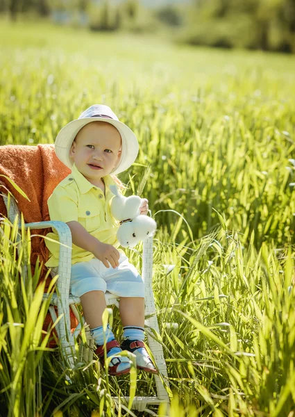 Little boy on the lawn, a child for a walk outdoors — Zdjęcie stockowe