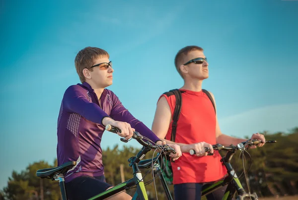 Two cyclists riding on a dirt road — Stok fotoğraf