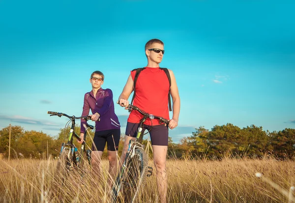 Two cyclists riding on a dirt road — Stok fotoğraf