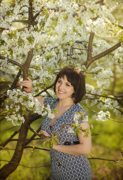 Jovem menina feliz bonita no jardim florido — Fotografia de Stock