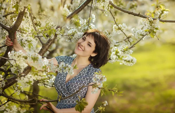 Young beautiful happy girl in the flowered garden — Stock fotografie