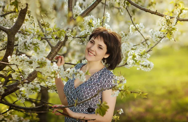 Young beautiful happy girl in the flowered garden — Stock fotografie