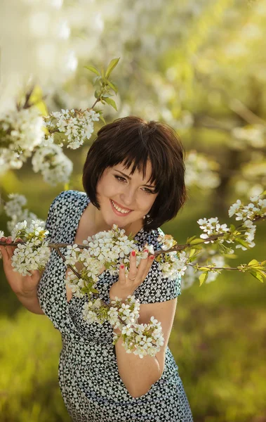 Young beautiful happy girl in the flowered garden — Stock Photo, Image