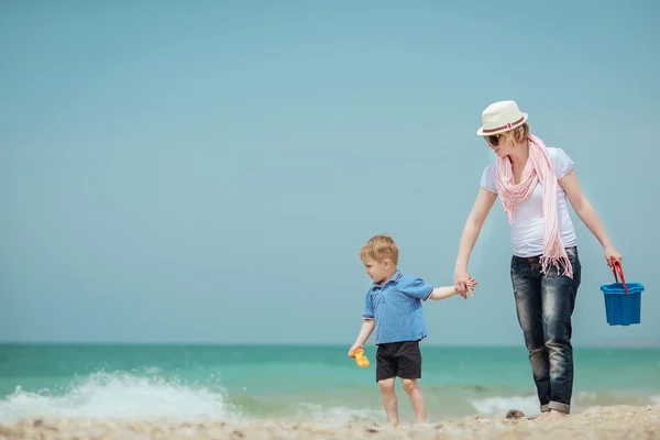 Счастливая мать с мальчиком на пляже . — стоковое фото