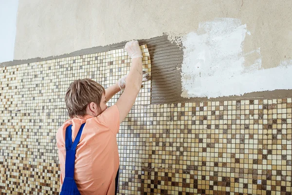 Laying Ceramic Tiles. Tiler placing ceramic wall tile in position over adhesive — Stock Photo, Image