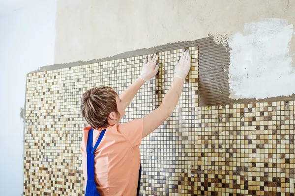 Pose de carreaux de céramique. Carrelage plaçant carrelage mural en céramique en position sur adhésif — Photo