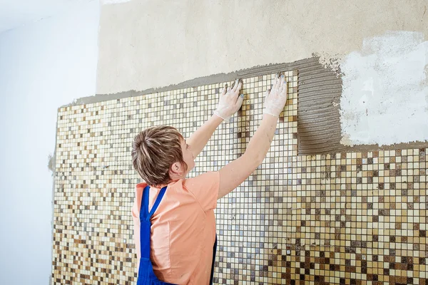 Laying Ceramic Tiles. Tiler placing ceramic wall tile in position over adhesive — Stock Photo, Image