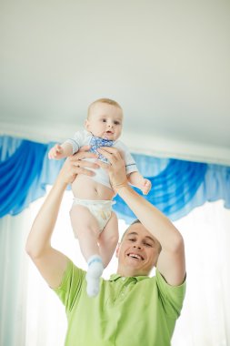 Onun kollarında evde genç oğluyla mutlu baba