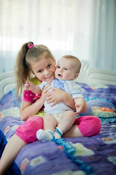 Indoor portrait of young happy smiling children, girls and boy, in bed, happy morning time — Stock Photo, Image