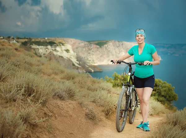 Kız bisikletçi deniz arka plan üzerinde — Stok fotoğraf