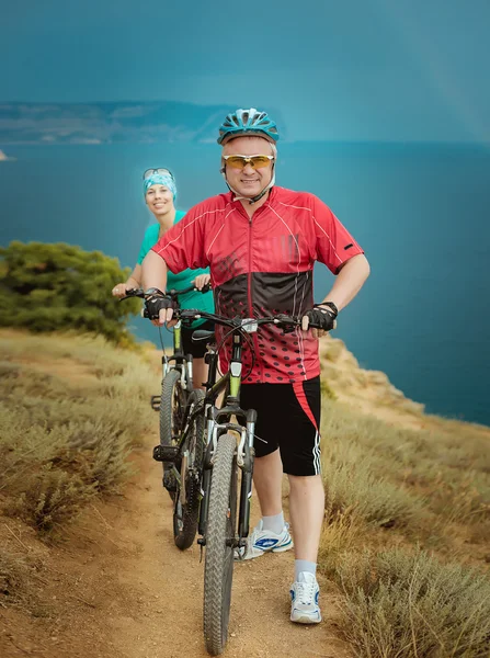 Ciclistas masculinos y femeninos en las montañas — Foto de Stock