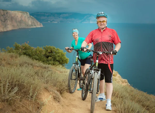 Ciclistas masculinos y femeninos en las montañas — Foto de Stock