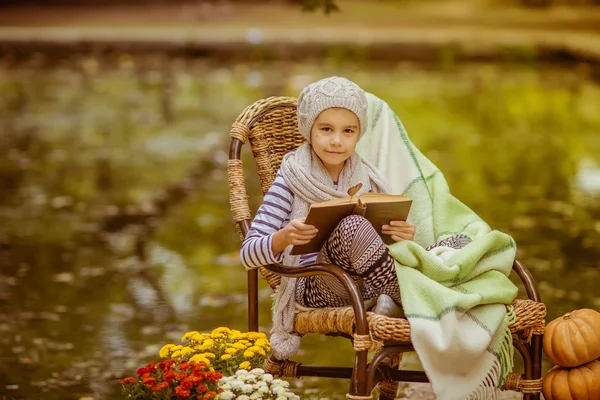 Fille lisant un livre à l'extérieur. Repos des enfants dans le parc d'automne — Photo