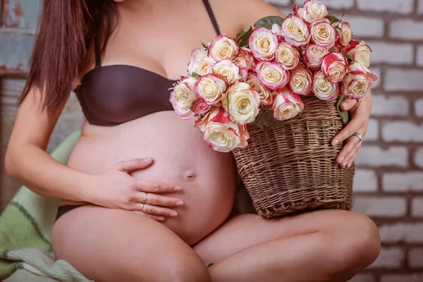 Mulher grávida com um buquê de rosas — Fotografia de Stock