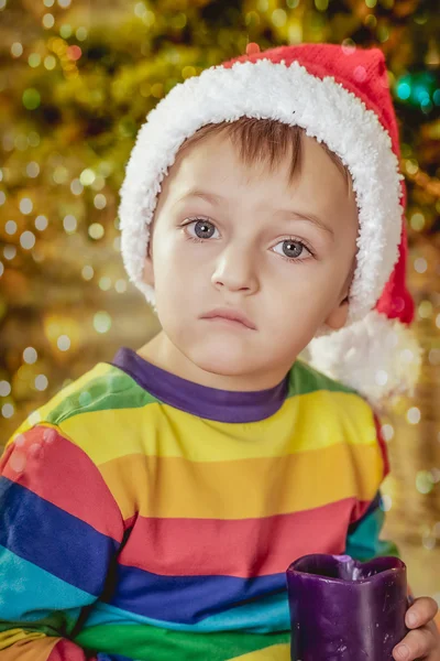 Boy in a hat of Santa with a gift — Stock Photo, Image