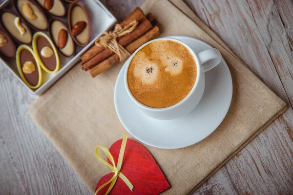 Tasse de café avec bonbons au chocolat et cannelle — Photo