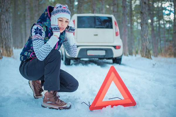 Vinterväg. flicka med en varningstriangel på en Vinterväg — Stockfoto