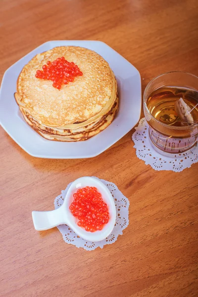 Pannenkoeken met rode kaviaar en een kopje thee — Stockfoto