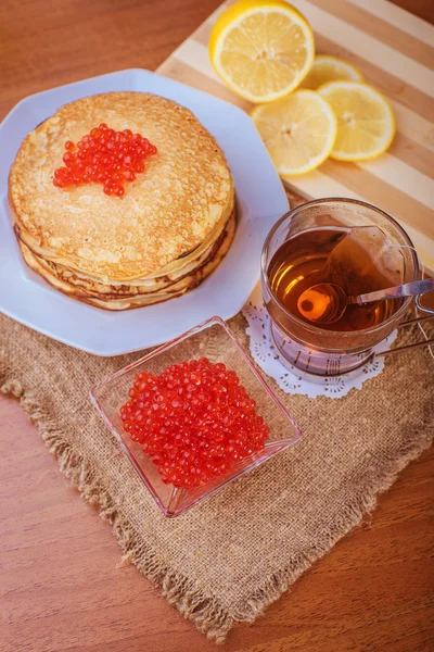 Pannenkoeken met rode kaviaar en een kopje thee — Stockfoto