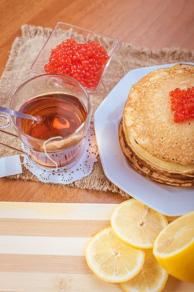 Pannenkoeken met rode kaviaar en een kopje thee — Stockfoto