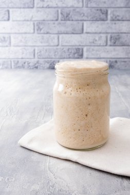 Ev yapımı ekmek ya da pizza için cam kavanozda taze buğday ekmeği ve mayalı ekmek..