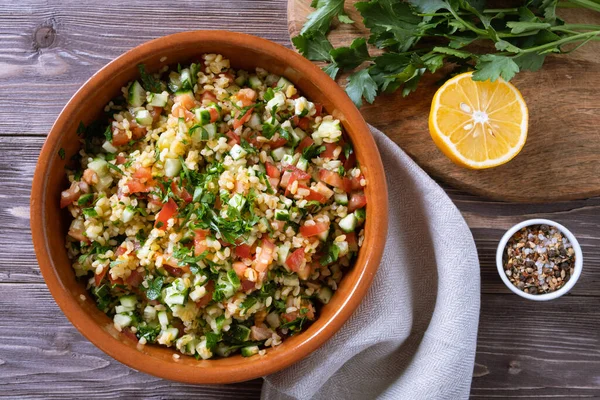 Tabouli Salat oder Tabule, Tabbouleh - einfacher mediterraner Salat mit Gemüse und Bulgur. — Stockfoto