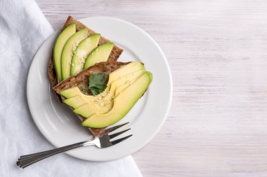 Vejetaryen avokado tostu ve kepekli ekmek.