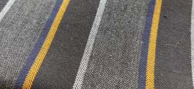 Turuncu ve koyu mavi çizgili açık renk kumaş. İç dekorasyon. Kumaşları gündelik tarzda giyin. İçerideki perdeler ve mobilyalar için yoğun malzeme.