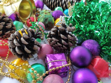 Noel süsü koleksiyonu. Güzel düzenlenmiş parlak Noel ağacı süslemeleri, yeşil folyo, hediyeler. Yeni yıl ve Noel için kırmızı, mor, sarı renkli dekor unsurları.