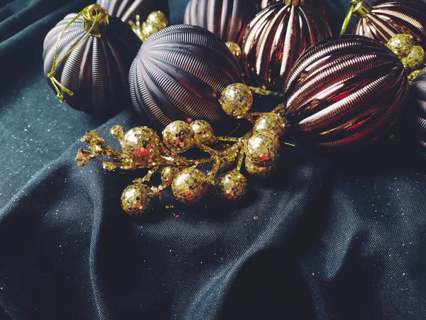 黒の背景に装飾 クリスマスの装飾や輝きを持つ新年とクリスマスのためのカード 茶色の光沢のある縞模様のボール 花と白い雪の結晶 果実と黄金の小枝 — ストック写真